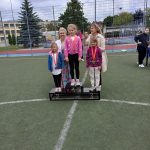 Dzieci stojące na podium podczas olimpiady sportowej. Na 2 miejscu stoi Zosia.