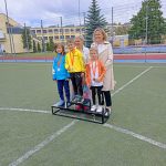 Dzieci stojące na podium podczas olimpiady sportowej. Na 3 miejscu stoi Antoś.