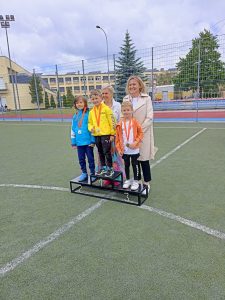 Dzieci stojące na podium podczas olimpiady sportowej. Na 3 miejscu stoi Antoś.