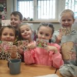 Dzieci pokazują prace uczestników warsztatów