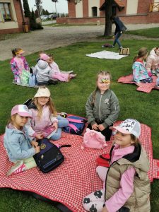 Dzieci siedzą na trawie