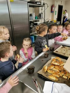 Dzieci w pracowni kulinarnej jedzą słodkie wypieki