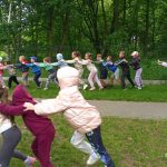 Dzieci stojąc w dwóch rzędach rywalizują w zawodach