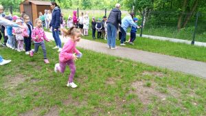 Dzieci stojąc w dwóch rzędach rywalizują w zawodach