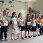 Siedmioro dzieci stoi w rzędzie trzymając atrybuty używane podczas inscenizacji
