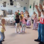 Dziecko wychodząc z tunelu rzuca piłkę do mężczyzny ubranego w koszulkę klubu Ostrovia.