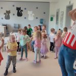 Dziecko wychodząc z tunelu rzuca piłkę do mężczyzny ubranego w koszulkę klubu Ostrovia.