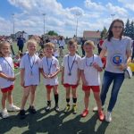 Szóstka dzieci i nauczycielka stoją boisku