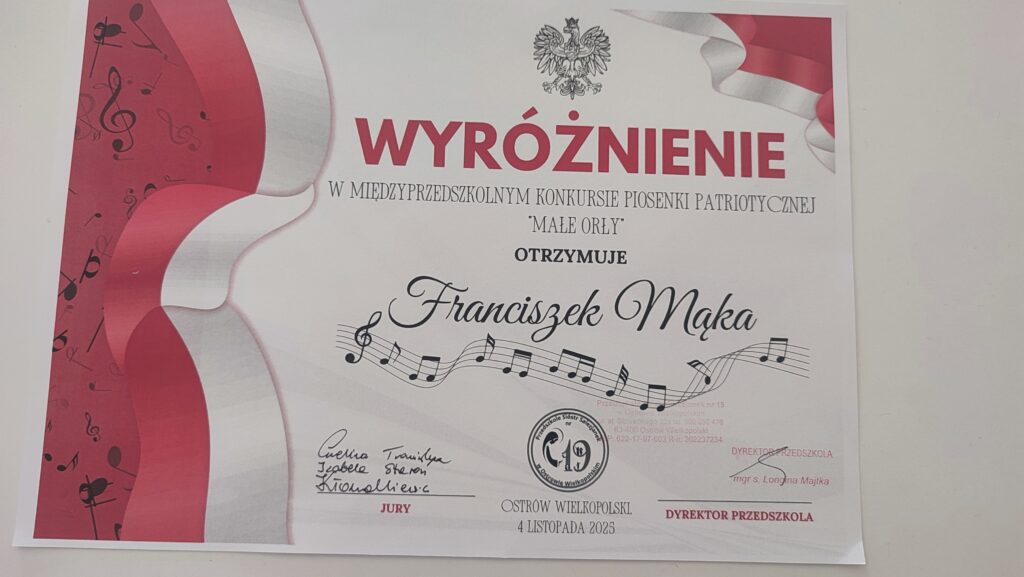 Biały dyplom z czerwonymi akcentami, na nim imię chłopca i wyróżnienie.