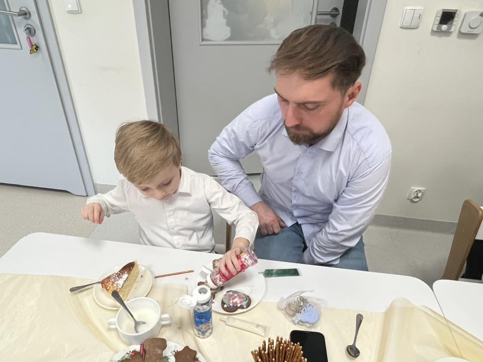 CHŁOPIEC Z TATĄ DEKORUJE PIERNIKI