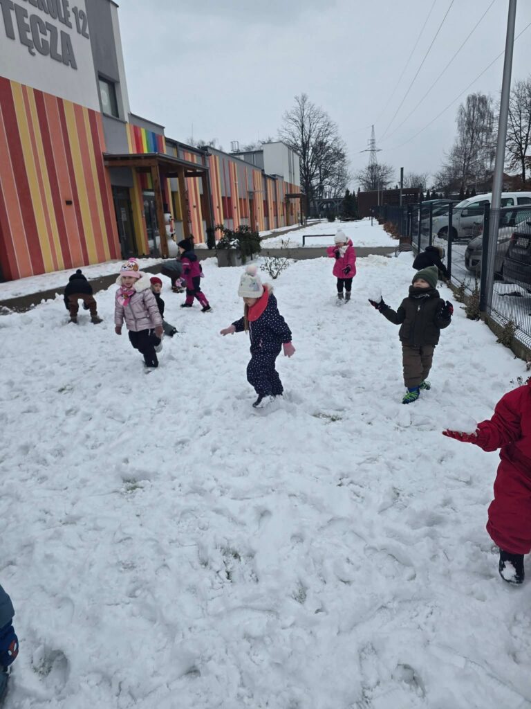 Dzieci lepią ze śniegu śnieżne kulki.