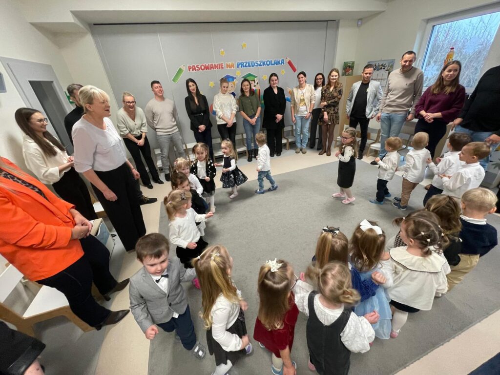 Rodzice i dzieci tańczą stojąc po obwodzie koła. Rodzice na zewnątrz koła, dzieci w środku.