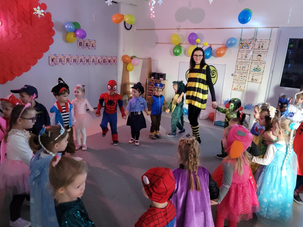 Dzieci tańczą w kole wraz z panią.