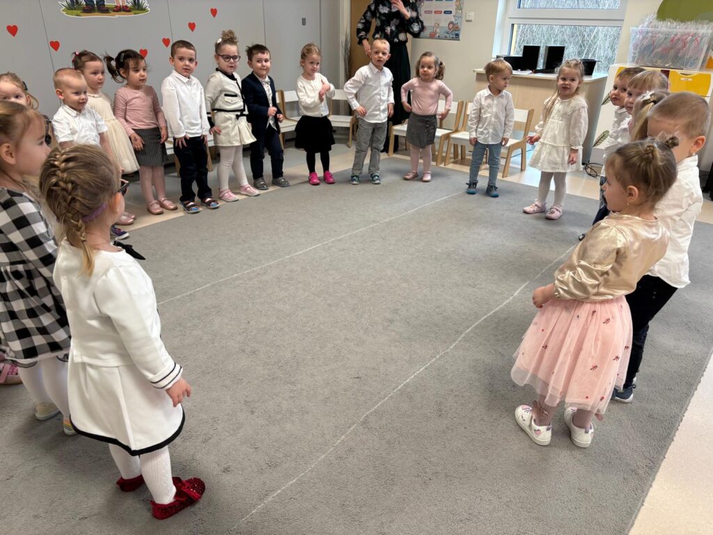 Dzieci stoją w kole i śpiewają piosenkę