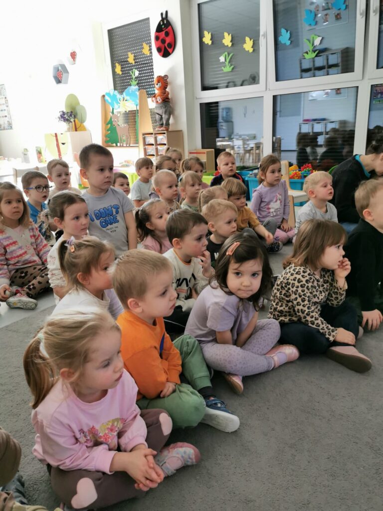 Dzieci siedzą na dywanie