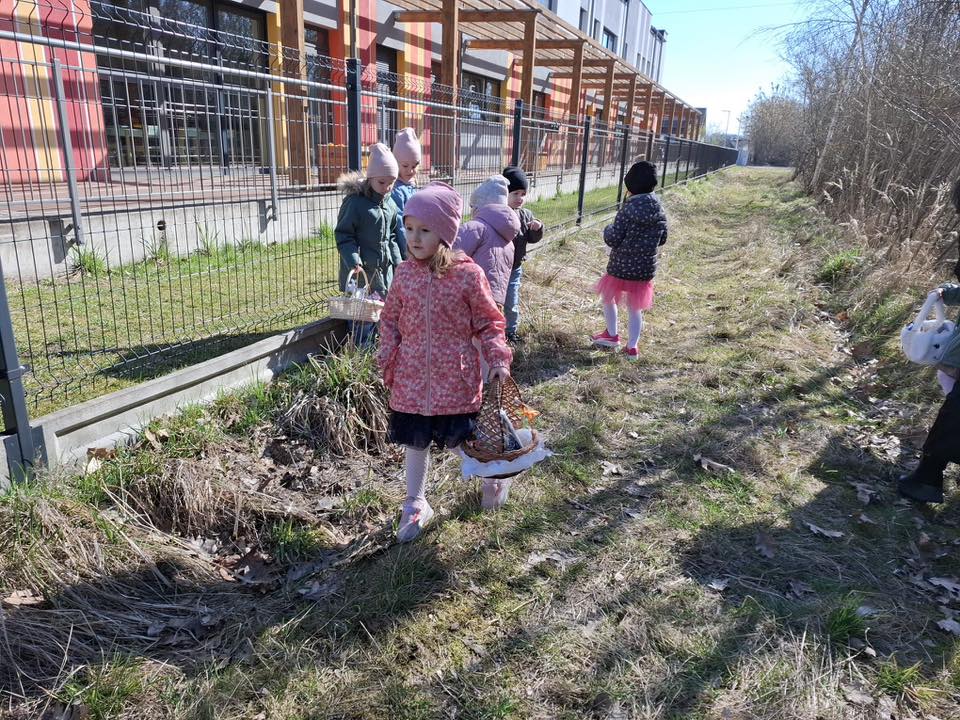 Dzieci na dworze szukają koszyczki wielkanocne