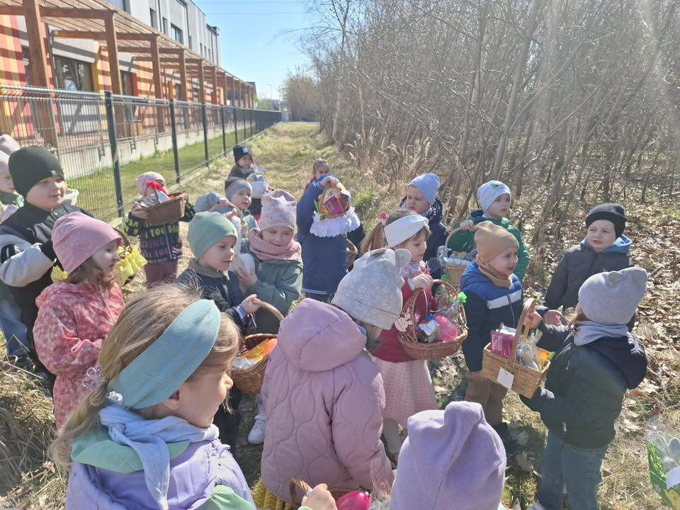 Dzieci na dworze trzymają koszyczki wielkanocne