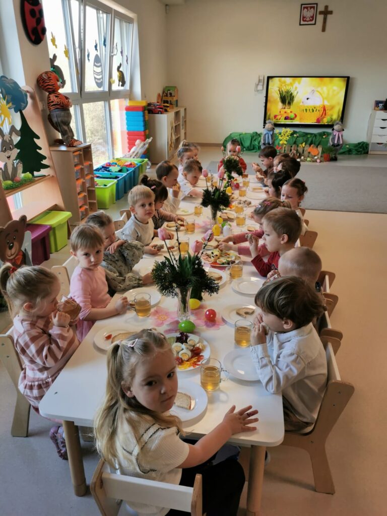 Dzieci siedzą przy wielkanocnym śniadaniu