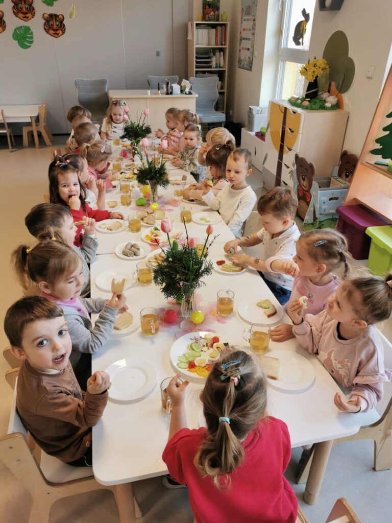 Dzieci siedzą przy wielkanocnym śniadaniu