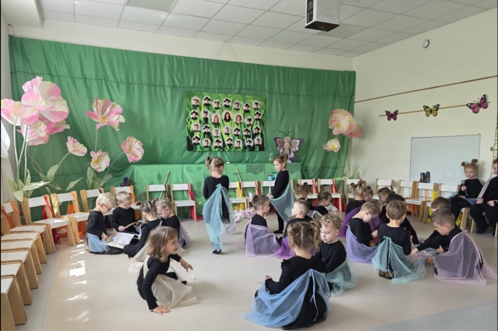 dzieci siedzą na podłodze przebrani za motyle