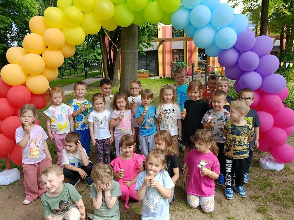 dzieci stoją pod girlandą z balonów