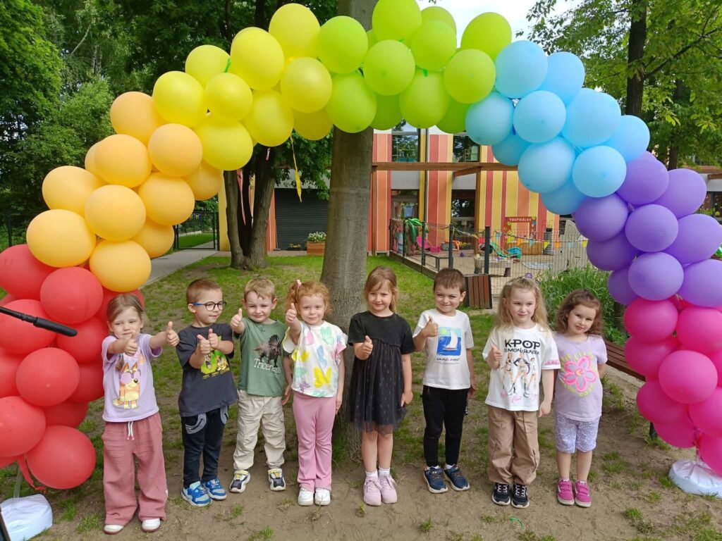 dzieci stoją pod girlandą z balonów