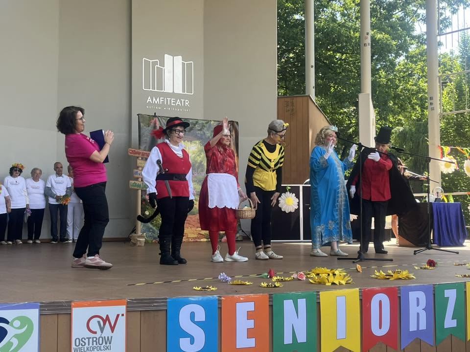 seniorzy przebrani za postaci z bajki stoją na scenie