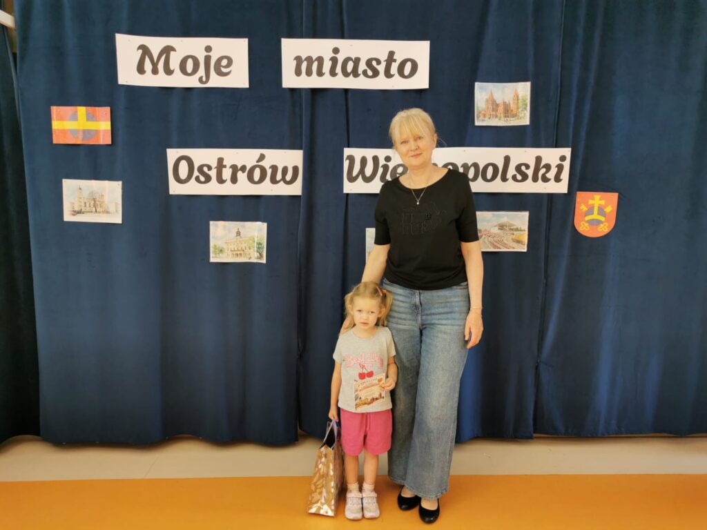 Nauczycielka pozuje do zdjęcia z dziewczynką