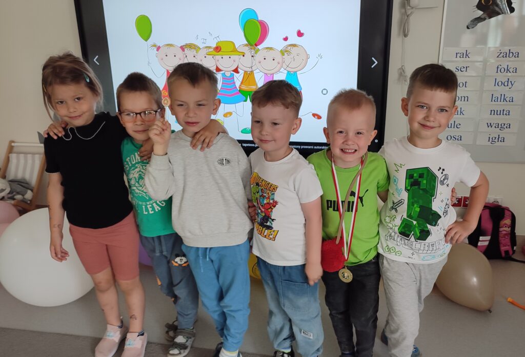 Grupa chłopców ubranych w kolorowe stroje pozuje do wspólnego zdjęcia.