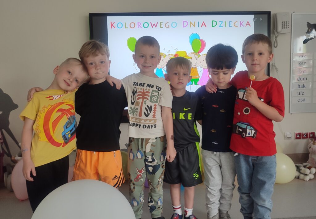 Grupa chłopców ubranych w kolorowe stroje pozuje do wspólnego zdjęcia.