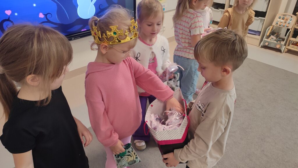Chłopiec wręcza prezent dziewczynce.